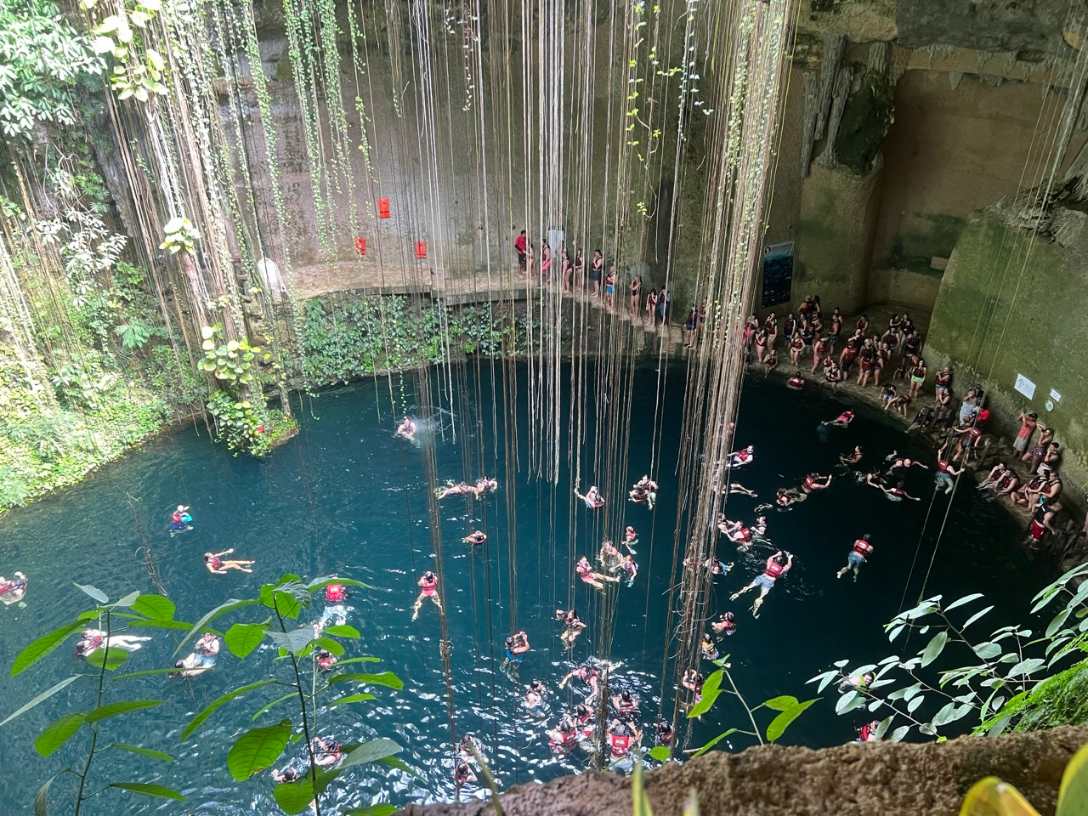Yucatán Cenote mit haengenden Lianen und Schwimmern bei Valladolid