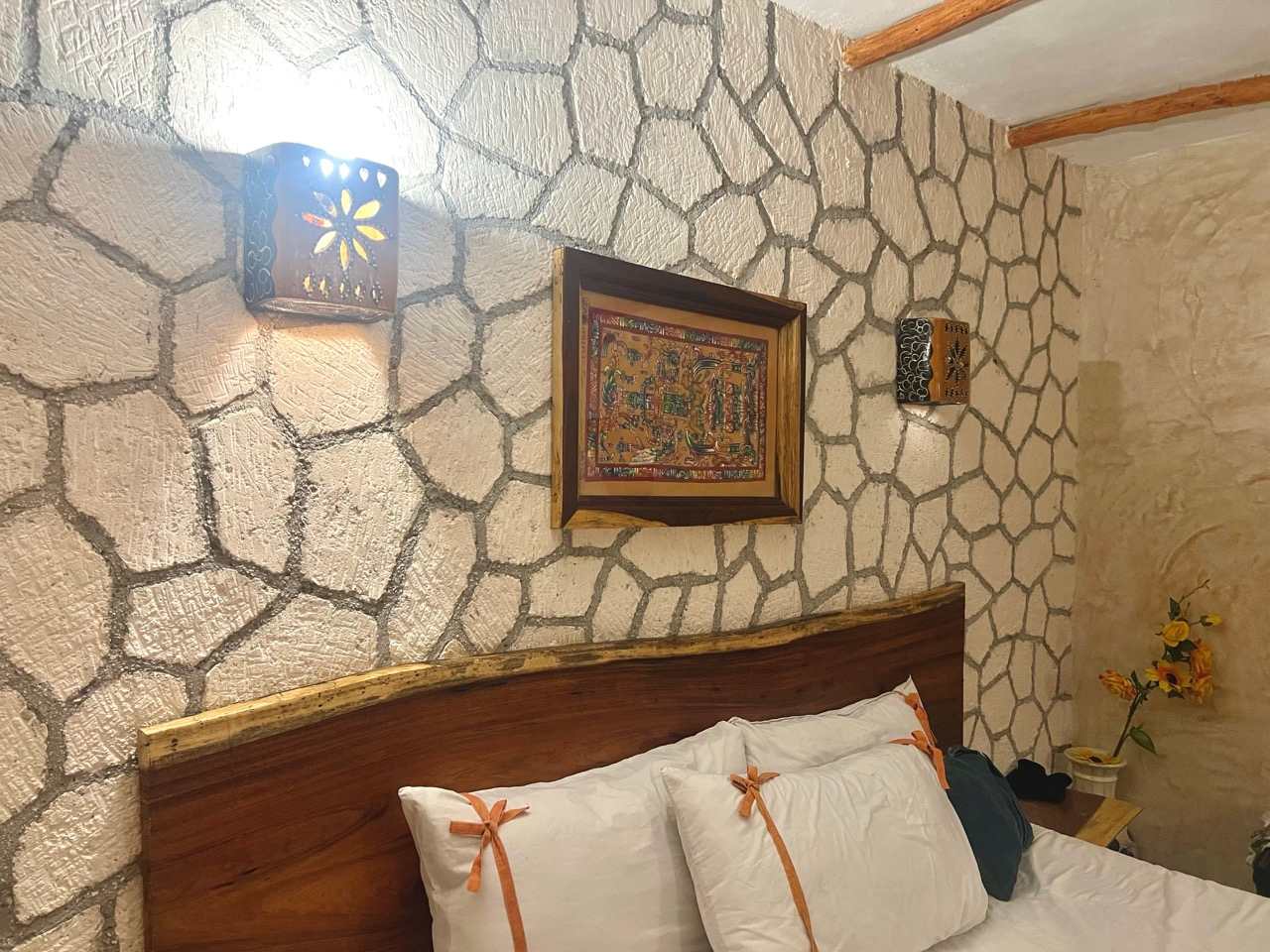 Hotelzimmer mit Natursteinwand und Doppelbett in Valladolid, Yucatán