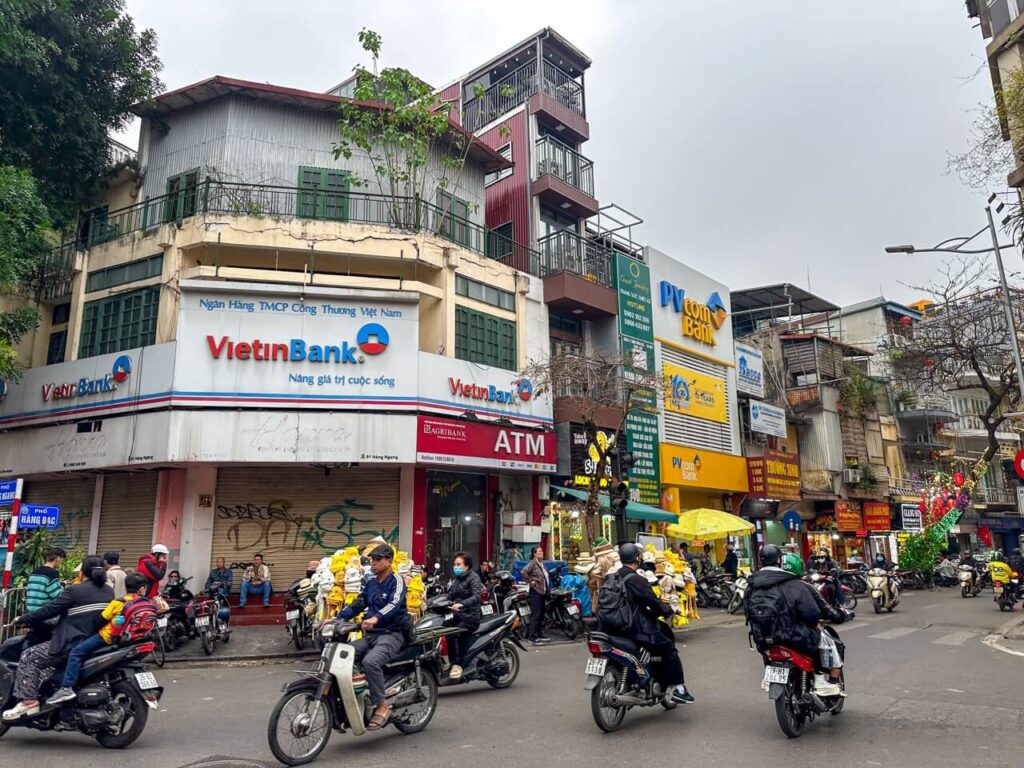 eSIM Vietnam: Kreuzung mit vielen Mopeds und Ladenzeilen in Hanoi