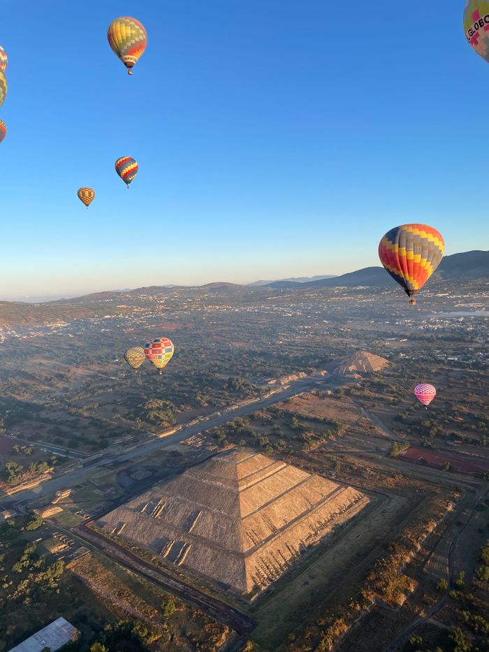 Aerial view of hot air balloons floating over the Teotihuacan Pyramids in Mexico.