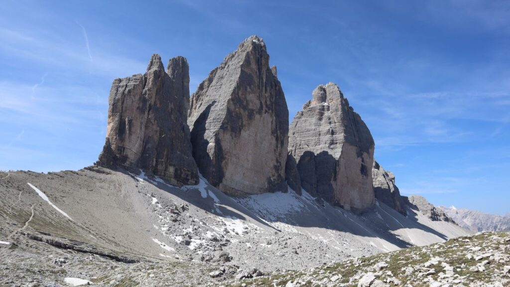 Stunning landscape of Tre Cime di Lavaredo mountain peaks under a clear blue sky.