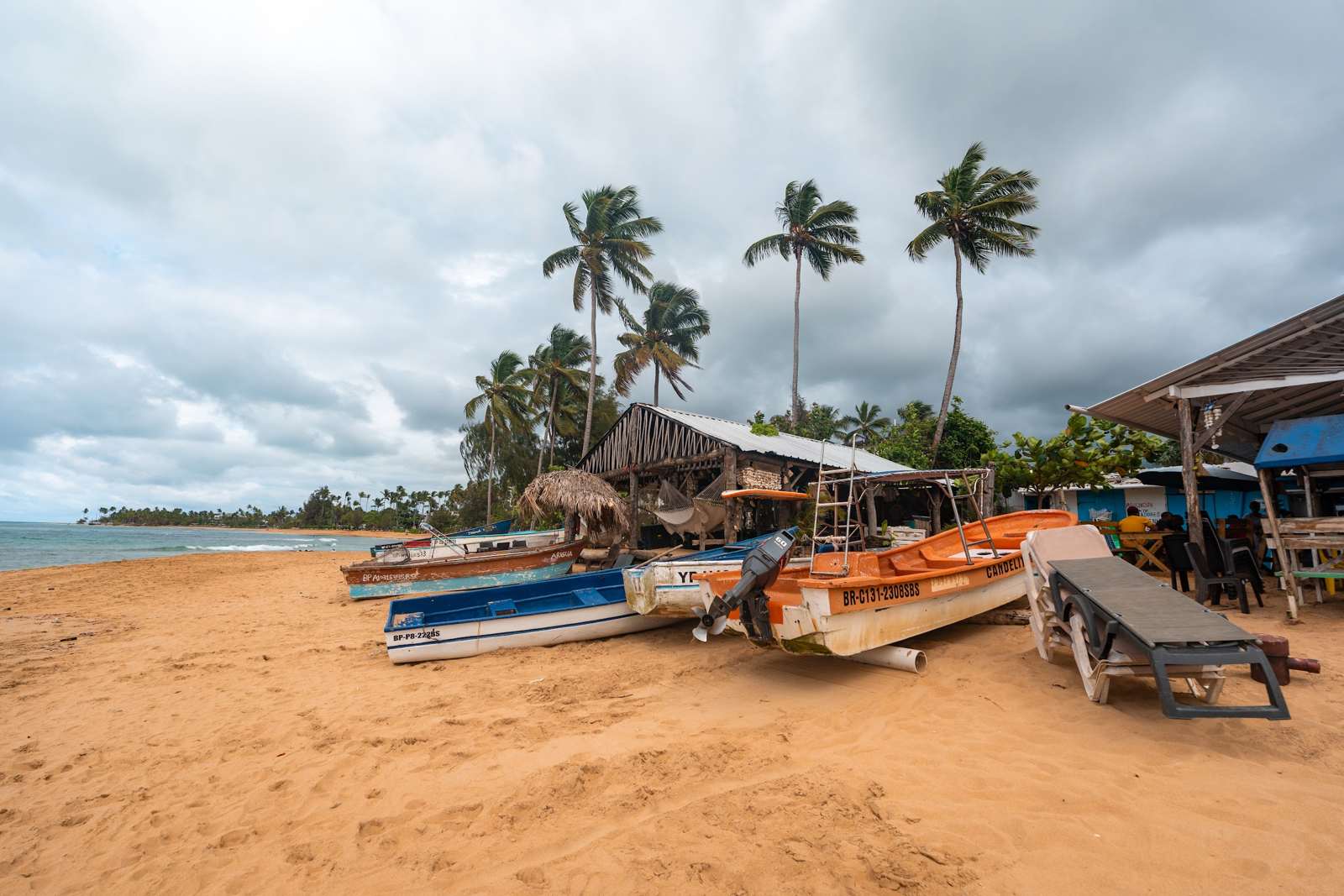 Beste Reisezeit Dominikanische Republik: Strand auf Samaná mit Booten unter Wolken