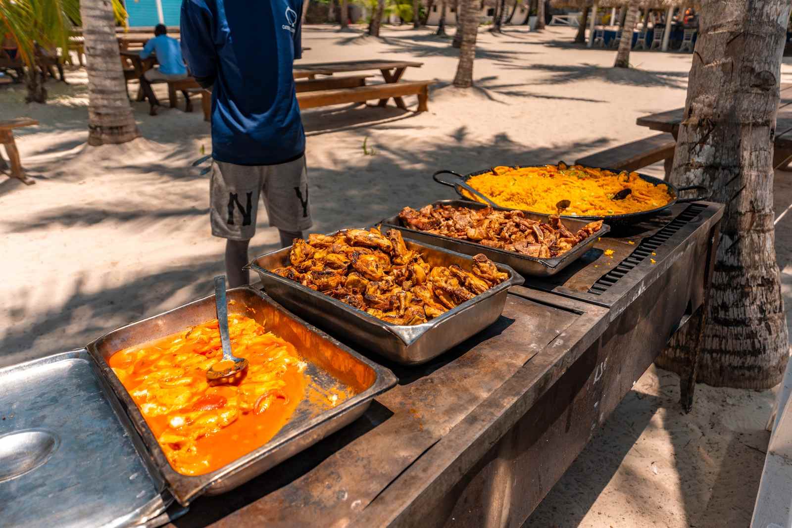 Buffet mit Paella, Hähnchen und Eintopf am Strand der Isla Saona