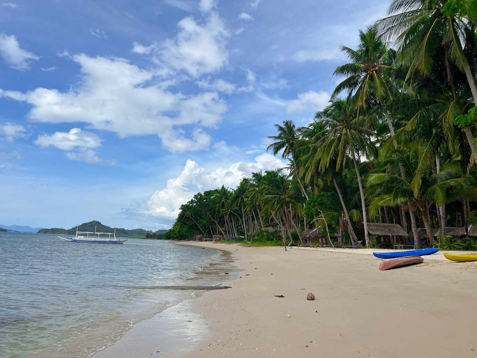 eSIM Philippinen: Strand von Port Barton auf Palawan mit Bangka-Boot im flachen Wasser