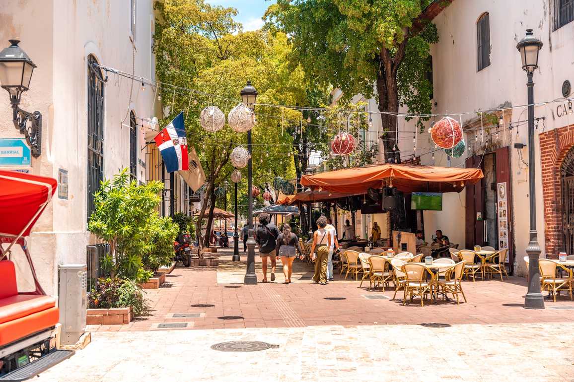 Gasse mit Cafés und Flagge in der Zona Colonial von Santo Domingo