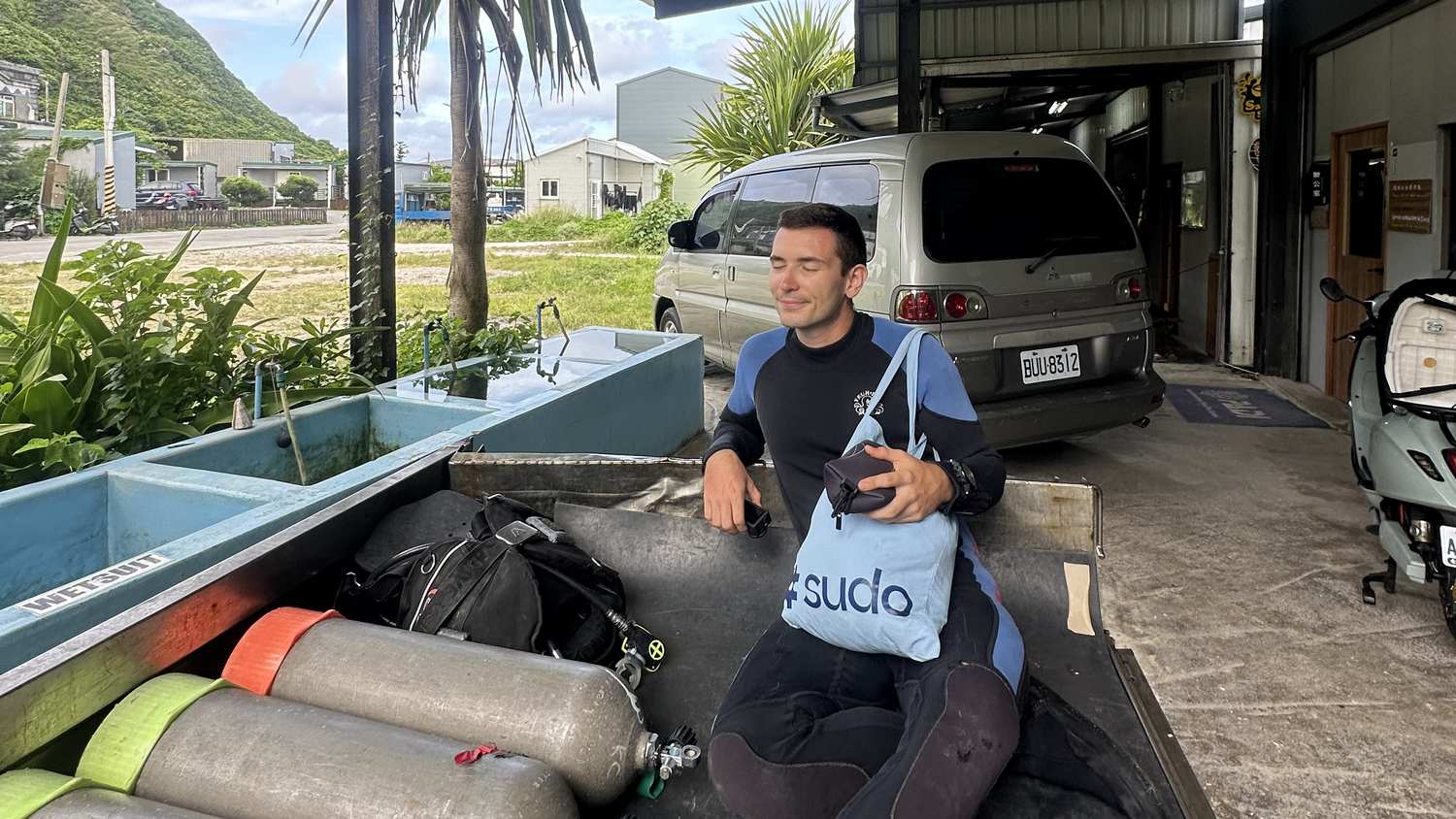 Jonathan sitzt zwischen Tauchflaschen auf Green Island Taiwan