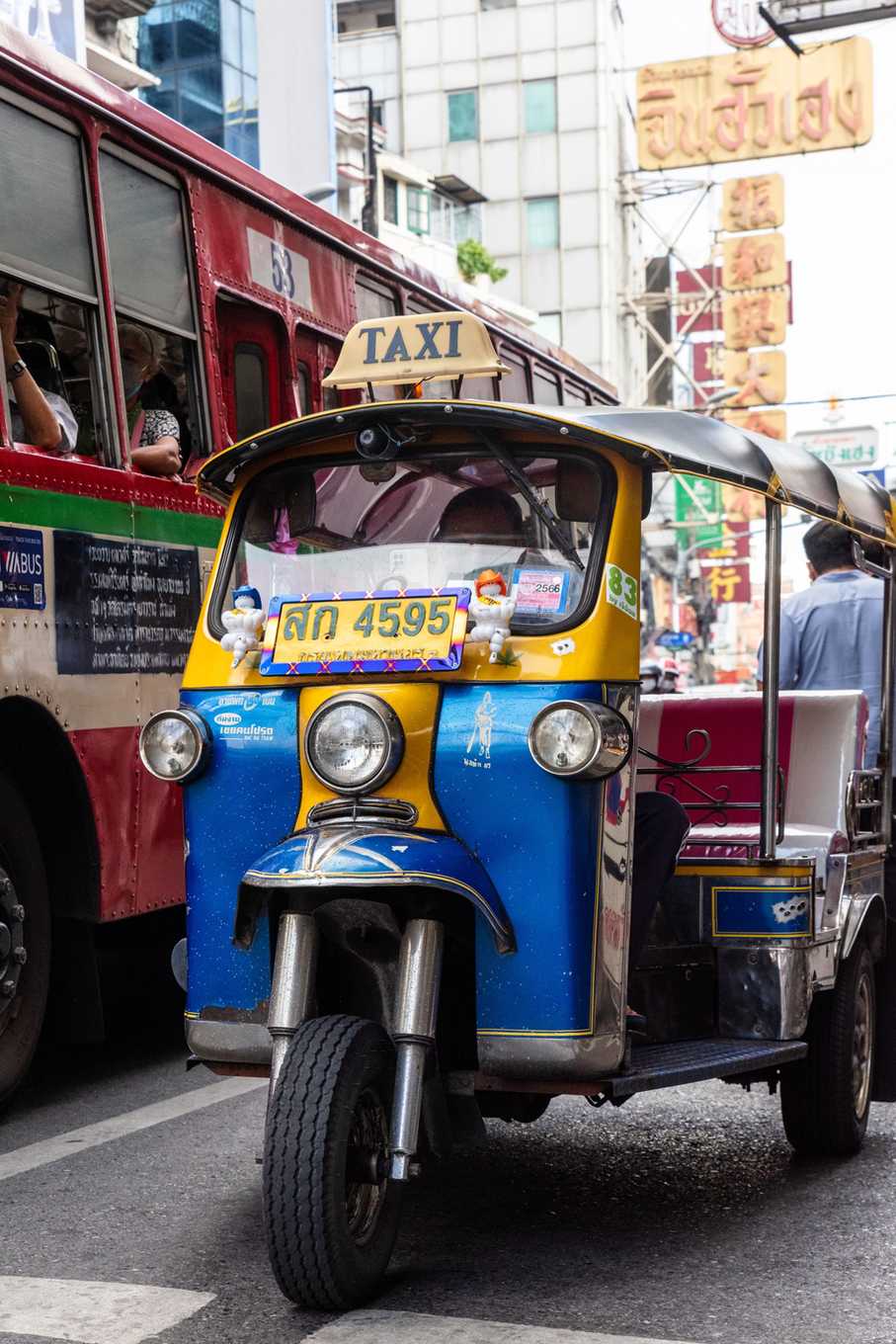 Tuk-Tuk in einer Straße von Bangkok mit Leuchtreklamen